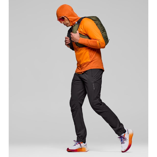 Side on-model view of Norrona Senja Flex1 Trackster pants for men in caviar black colour