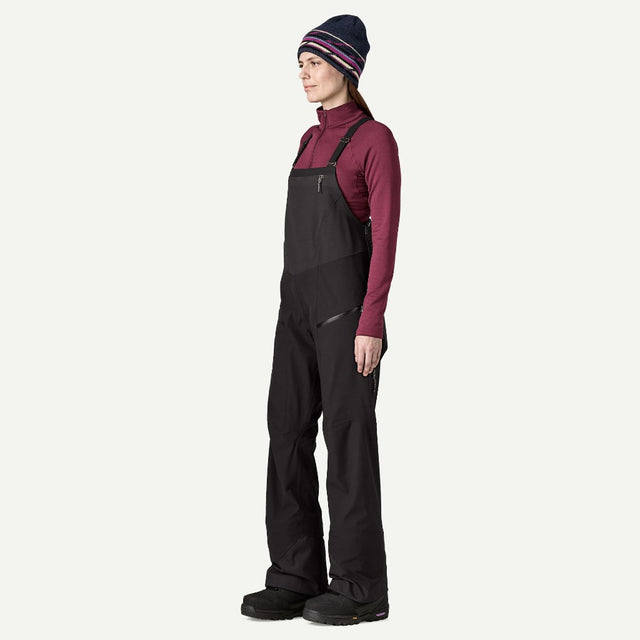 Side on-model view of Patagonia's Snow Drifter Bibs for women in black colour