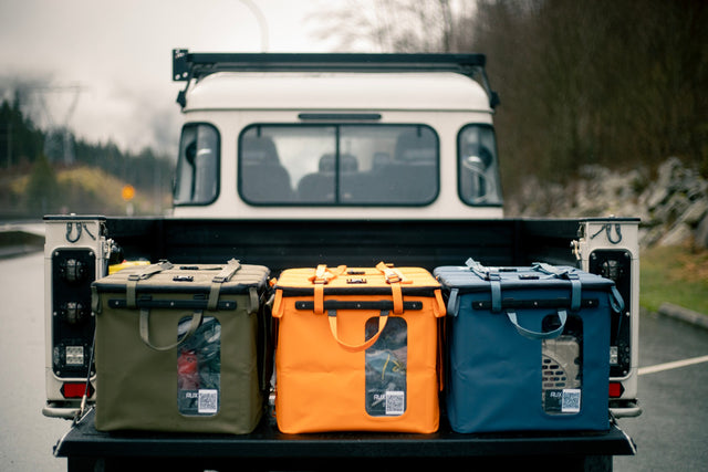 Three RUX gear boxes in the back of a truck with a forest background