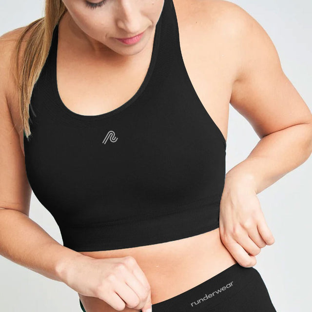 Model wearing women's black runderwear balance sports bra