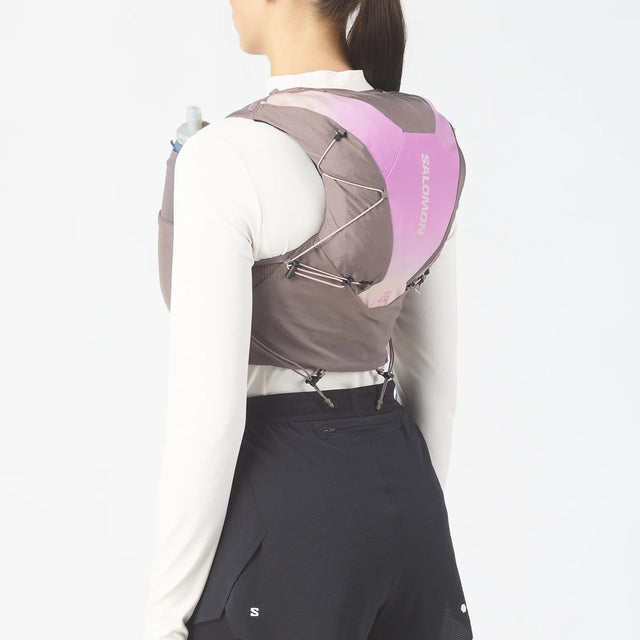 Back on-model view of women's purple/grey Salomon ADV 12 running vest