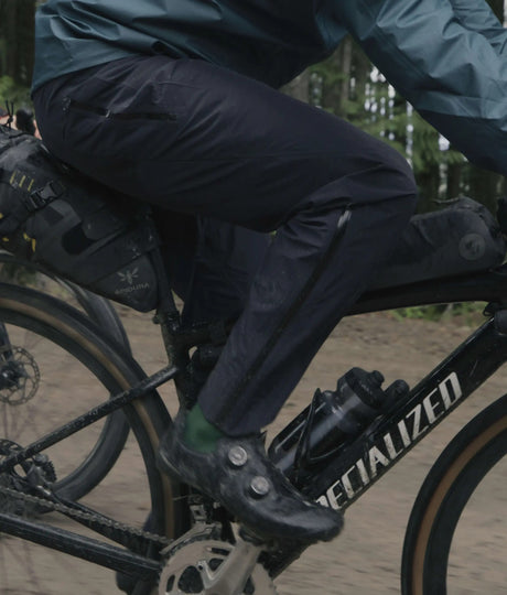 Person riding a Specialized bicycle on a dirt road with a forest in the background