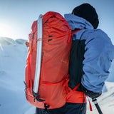 Lifestyle photo of Blue Ice Firecrest 38 skiing and hiking back pack in Red Clay colour
