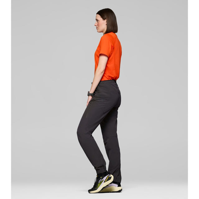 Side on-model view of Norrona Senja Flex1 Trackster pants for women in caviar black colour