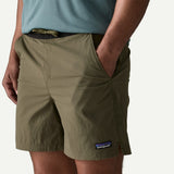 Front pocket detail on-model view of Patagonia baggies lights 6" men's in basin green colour
