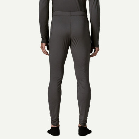 Back on-model view of Patagonia's Men Capilene Lightweight Bottoms in black colour