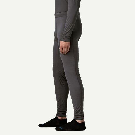 Side on-model view of Patagonia's Men Capilene Lightweight Bottoms in black colour