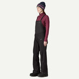 Side on-model view of Patagonia's Snow Drifter Bibs for women in black colour