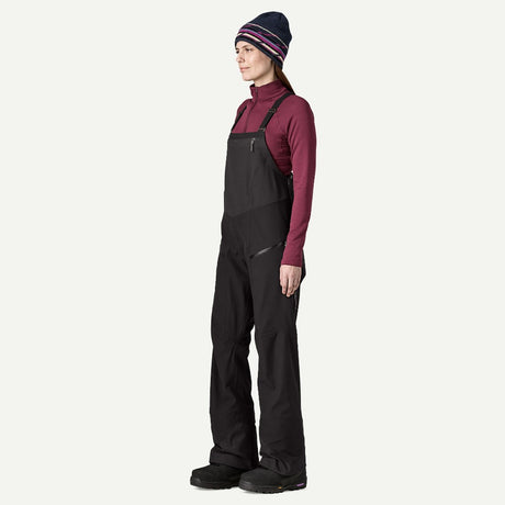 Side on-model view of Patagonia's Snow Drifter Bibs for women in black colour