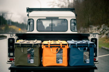 Three RUX gear boxes in the back of a truck with a forest background