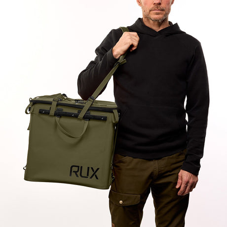 Person holding a green RUX bag with shoulder strap