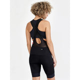 Back view on model of women's black Craft ADV gravel bib bike shorts