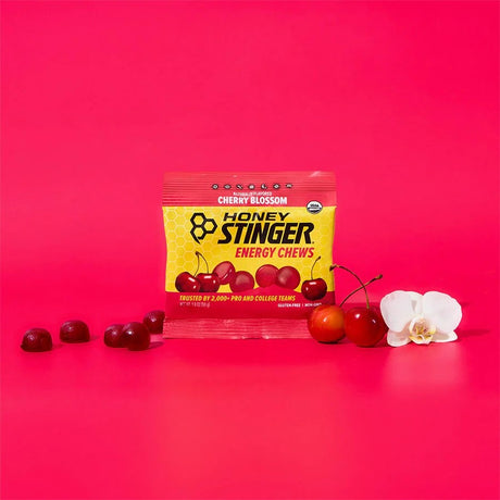 Honey Stinger energy chews package with cherries and flowers on a red background