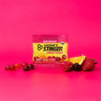 Honey Stinger energy chews package with fruit on a pink background