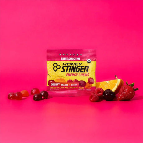Honey Stinger energy chews package with fruit on a pink background