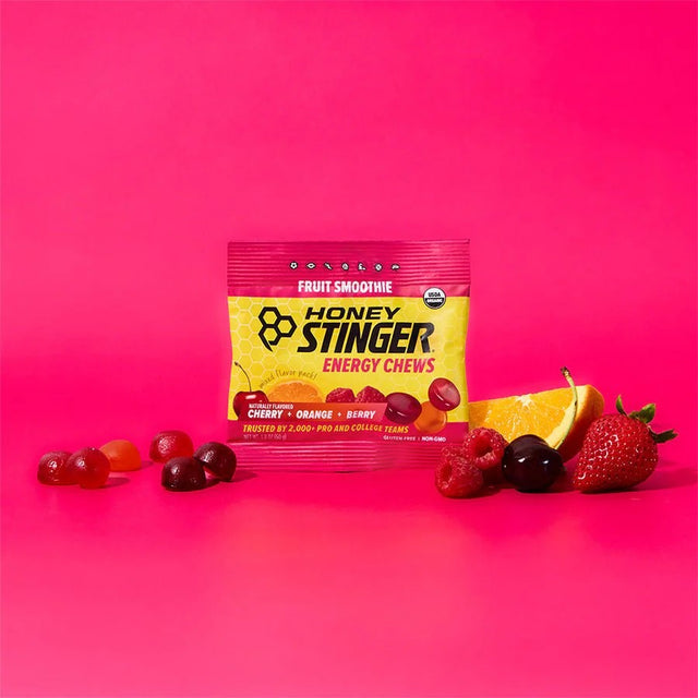Honey Stinger energy chews package with fruit on a pink background