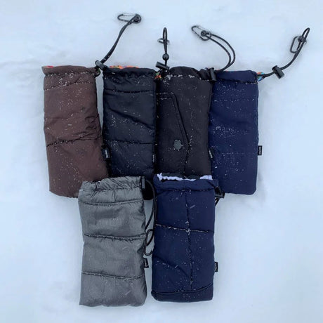 Set of five phone warmer bags in different colors on a snowy background