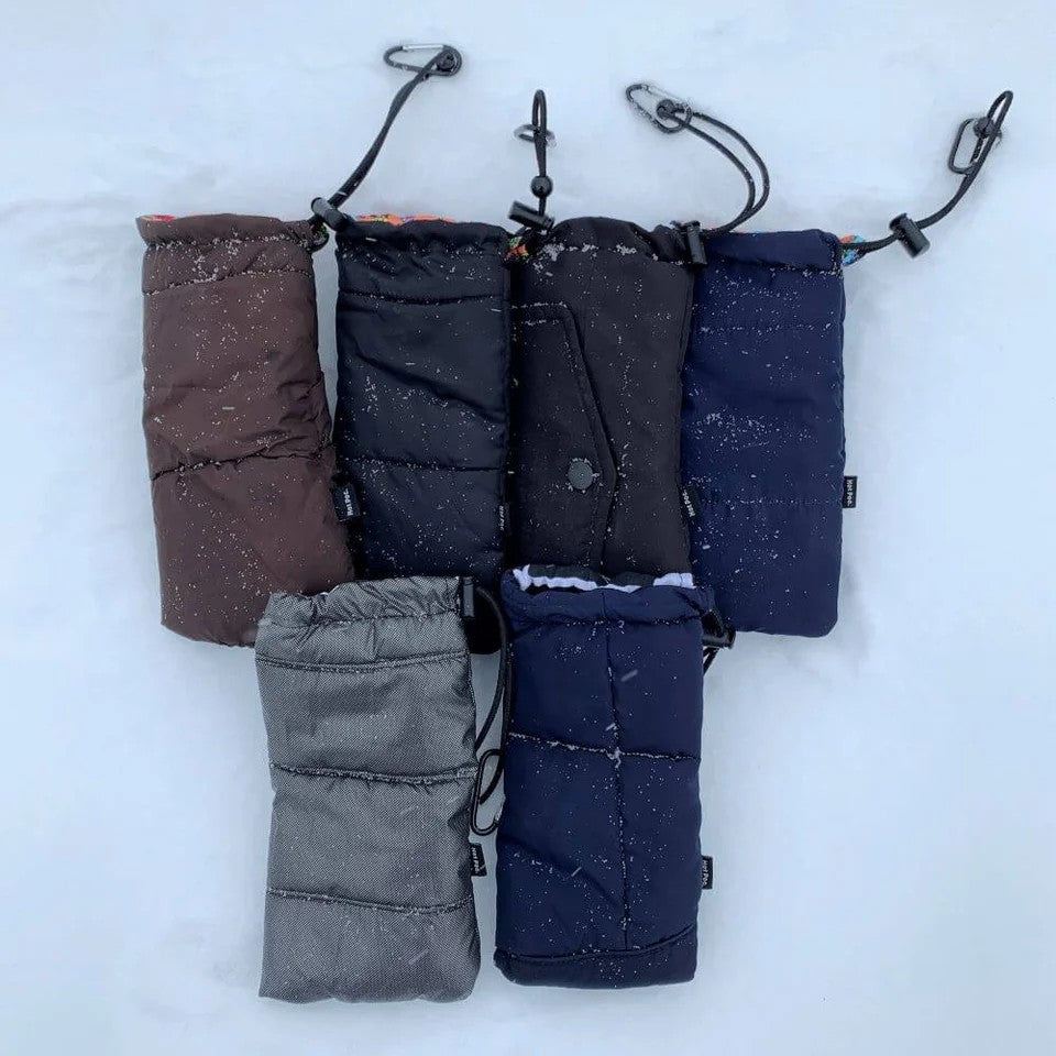 Set of five phone warmer bags in different colors on a snowy background