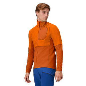 Side on-model view of men's norrona lyngen alpha90 jacket in exuberance (orange) colour