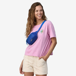 Model wearing patagonia black hole mini hip pack in passage blue bandolier style