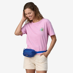 Model wearing patagonia black hole mini hip pack in passage blue