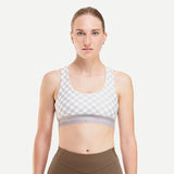 Front on-model view of women's checkered grey/white Peppermint Cycling sports bra