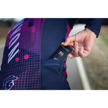 Biker pulling a Precision Fuel 30 gel out of their cycling bib