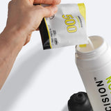 Hand pouring a packet of Precision Hydration 500 electrolyte mix into a water bottle