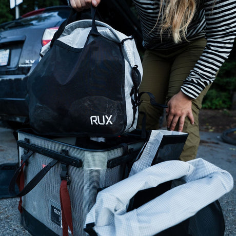Person packing a RUX mesh bag into a gear box