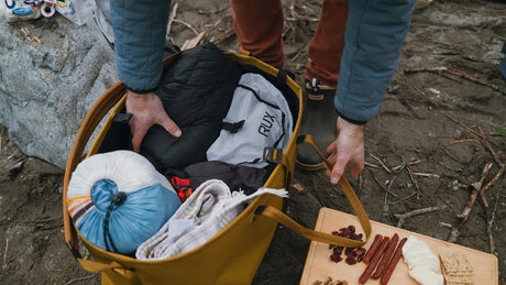 Person packing items into a bronze RUX tote bag