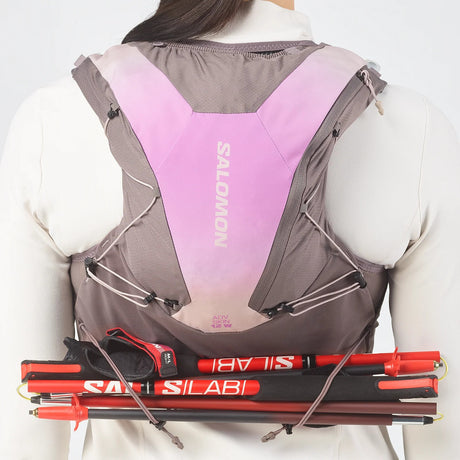 Back view of women's purple/grey Salomon ADV 12 running vest with poles attached