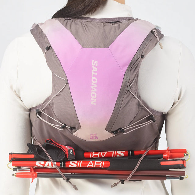 Back view of women's purple/grey Salomon ADV 12 running vest with poles attached
