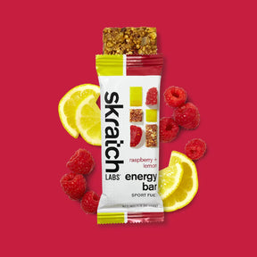 Skratch Labs raspberry lemon energy bar with lemons and raspberries on a red background