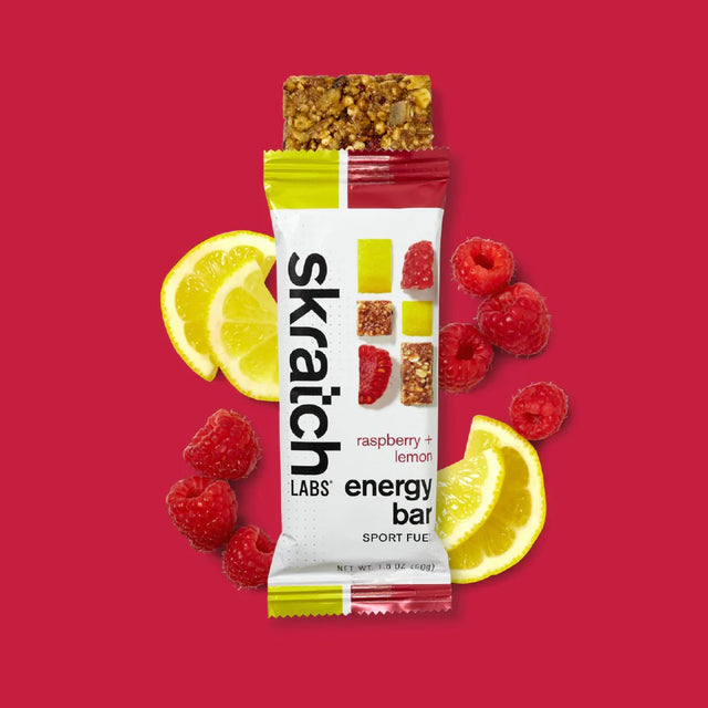 Skratch Labs raspberry lemon energy bar with lemons and raspberries on a red background