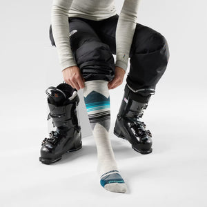 Skier putting on a pair of women's patterned Smartwool ski socks