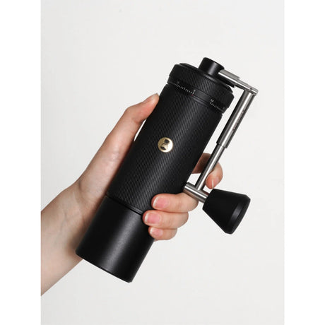 Hand holding a Timemore S3 ESP manual coffee grinder