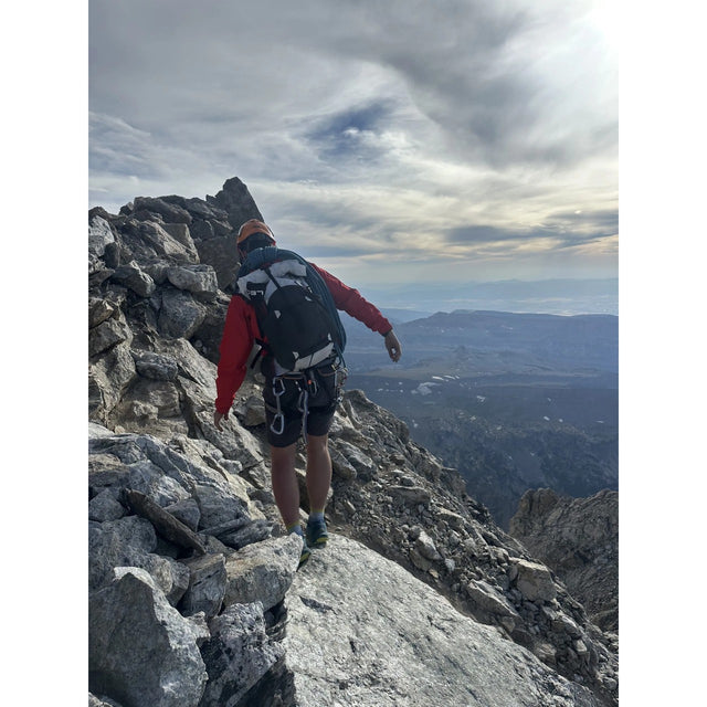 Person wearing the UltrAspire Altruist hydration pack while walking along a ridge