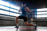 Person performing a lunge in a boxing ring with large windows in the background
